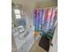 Bright bathroom featuring a shower with a colorful, tree-themed curtain, a pedestal sink, and tile flooring at 1545 N Nc 87, Elon, NC 27244