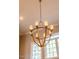 Close-up of ornate chandelier with brass finish and classic design illuminating the room with natural light at 1616 Kirkby Ln, Raleigh, NC 27614