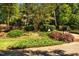 Landscaped front yard with mature trees, colorful bushes, and a brick mailbox creates inviting curb appeal at 1616 Kirkby Ln, Raleigh, NC 27614