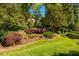 Beautifully landscaped front yard with mature trees and colorful bushes creates attractive curb appeal at 1616 Kirkby Ln, Raleigh, NC 27614