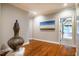 Inviting hallway with hardwood floors, neutral paint, modern decor, and ample natural light from nearby windows at 1616 Kirkby Ln, Raleigh, NC 27614
