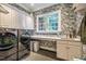Well-appointed laundry room with modern washer and dryer, countertop space, and stylish wallpaper at 1616 Kirkby Ln, Raleigh, NC 27614