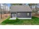 A view of the backyard featuring a gray house with a gray roof, a patio and grass at 163 Nashua Dr, Louisburg, NC 27549