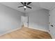 A bedroom featuring light gray walls, and wood-look flooring, ceiling fan and double door closet at 163 Nashua Dr, Louisburg, NC 27549