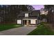 Charming two-story home with dark siding, covered front porch, and well-maintained lawn at 163 Nashua Dr, Louisburg, NC 27549