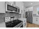 Close up of modern kitchen featuring stainless steel appliances, white cabinets, quartz countertops, and subway tile backsplash at 163 Nashua Dr, Louisburg, NC 27549