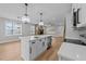 Open-concept kitchen with large island, white cabinets, stainless appliances, and hardwood flooring throughout at 163 Nashua Dr, Louisburg, NC 27549