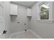 Laundry room featuring white cabinets, tile floor, light gray walls and utility hookups at 163 Nashua Dr, Louisburg, NC 27549