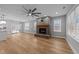 Bright living room with a brick fireplace, large windows, and modern ceiling fan at 163 Nashua Dr, Louisburg, NC 27549