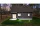 Charming home rear exterior with sliding door, concrete patio, and manicured lawn surrounded by mature trees at 163 Nashua Dr, Louisburg, NC 27549