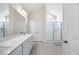 Bright bathroom with a dual sink vanity, a walk-in shower with glass door, and neutral colored hexagonal floor tiles at 212 Thunder Forest Ln, Wendell, NC 27591