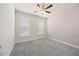 Comfortable bedroom with two bright windows, plush carpet, and a modern ceiling fan at 212 Thunder Forest Ln, Wendell, NC 27591