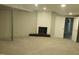 Open basement area featuring a decorative fireplace, carpeted floors, and white walls at 2602 Fayetteville St, Durham, NC 27707