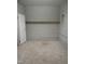 Unfinished basement space featuring concrete walls, carpeted floor, and overhead shelving at 2602 Fayetteville St, Durham, NC 27707