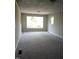 Spacious carpeted living room featuring a large window and neutral-colored walls at 2602 Fayetteville St, Durham, NC 27707