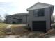 Two-story home showcasing a gray brick exterior, a black garage door, and a small backyard at 2602 Fayetteville St, Durham, NC 27707