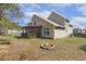 View of a tan two story home featuring a fire pit, covered porch and spacious backyard at 288 Joseph Alexander Dr, Fuquay Varina, NC 27526