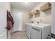 Functional laundry room featuring modern washer and dryer, overhead storage, and convenient access to the exterior at 288 Joseph Alexander Dr, Fuquay Varina, NC 27526