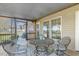 A screened-in porch featuring a metal table with metal chairs atop an outdoor rug at 288 Joseph Alexander Dr, Fuquay Varina, NC 27526