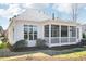 Back exterior view of the home featuring a screened porch, deck area, and landscaped yard at 301 Kinsale Dr, Chapel Hill, NC 27517