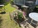 Inviting backyard patio with a grill and blooming pink peonies, perfect for outdoor entertaining and relaxation at 301 Kinsale Dr, Chapel Hill, NC 27517