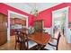 Elegant dining room features a chandelier, cherry wood table and red accent wall at 301 Kinsale Dr, Chapel Hill, NC 27517