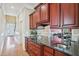 Kitchen counter and cabinets with granite countertops and stainless steel sink and view of hallway at 301 Kinsale Dr, Chapel Hill, NC 27517