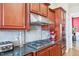 Close up of a gourmet kitchen with stainless gas cooktop and cherry cabinets at 301 Kinsale Dr, Chapel Hill, NC 27517