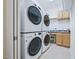 Bright laundry room featuring two stacked white washer and dryer units, cabinets, and a sink at 301 Kinsale Dr, Chapel Hill, NC 27517