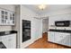 Modern kitchen featuring white cabinets, black appliances, and hardwood flooring at 317 Shadowbrook Dr, Burlington, NC 27215