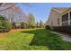 Spacious backyard featuring a well-maintained lawn, mature trees, and a brick home at 321 Weycroft Grant Dr, Cary, NC 27519