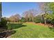 Spacious backyard featuring a manicured lawn and mature trees at 321 Weycroft Grant Dr, Cary, NC 27519