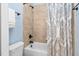 Bathroom with a shower-tub combo with a beige tile wall and patterned shower curtain at 321 Weycroft Grant Dr, Cary, NC 27519