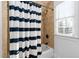 Bathroom featuring a bathtub with a striped shower curtain and tiled wall at 321 Weycroft Grant Dr, Cary, NC 27519