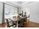 Light-filled dining room with a wooden table, six chairs, hardwood floors, and elegant arched entry at 321 Weycroft Grant Dr, Cary, NC 27519