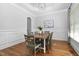 Elegant dining room featuring hardwood floors, wainscoting, and a chandelier above the table set for six at 321 Weycroft Grant Dr, Cary, NC 27519