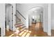 Bright foyer with hardwood floors, staircase, and arched doorway, seamlessly flowing into the living space at 321 Weycroft Grant Dr, Cary, NC 27519