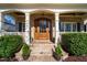 Charming brick home entrance with brick steps, manicured bushes, and a beautiful wooden front door at 321 Weycroft Grant Dr, Cary, NC 27519