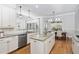 Modern kitchen with white cabinets, granite countertops, stainless steel appliances, and wood flooring at 321 Weycroft Grant Dr, Cary, NC 27519