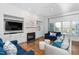 Bright living room with fireplace, built-in shelving, hardwood floors, and large windows at 321 Weycroft Grant Dr, Cary, NC 27519