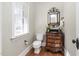 Elegant powder room featuring a decorative mirror, ornate vanity, and natural light at 321 Weycroft Grant Dr, Cary, NC 27519