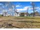 Large, grassy backyard with trees surrounding the property, offering plenty of space at 34 Triton Ct, Clayton, NC 27520