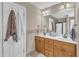 Well-lit bathroom with double sinks, wooden cabinets, and a large mirror at 34 Triton Ct, Clayton, NC 27520