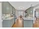 Spacious kitchen with green cabinets, stainless appliances, and a view to the dining area at 34 Triton Ct, Clayton, NC 27520