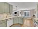 Open kitchen layout featuring green cabinets, granite counters, and an island with a sink at 34 Triton Ct, Clayton, NC 27520