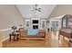 Spacious living room with hardwood floors, a ceiling fan, a fireplace with a decorative mantel, and abundant natural light at 34 Triton Ct, Clayton, NC 27520
