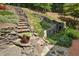 Backyard with stone steps, landscaping, and a peaceful waterfall feature at 405 Silver Creek Trl, Chapel Hill, NC 27514
