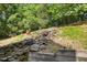 Stone waterfall and landscaped hillside adding a touch of nature to this home at 405 Silver Creek Trl, Chapel Hill, NC 27514