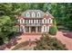 Elegant brick home with white shutters, covered porch, and manicured front yard surrounded by mature trees at 405 Silver Creek Trl, Chapel Hill, NC 27514