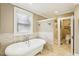 This bathroom features a standalone tub with a window and a luxurious walk-in shower at 411 Circle Dr, Burlington, NC 27215